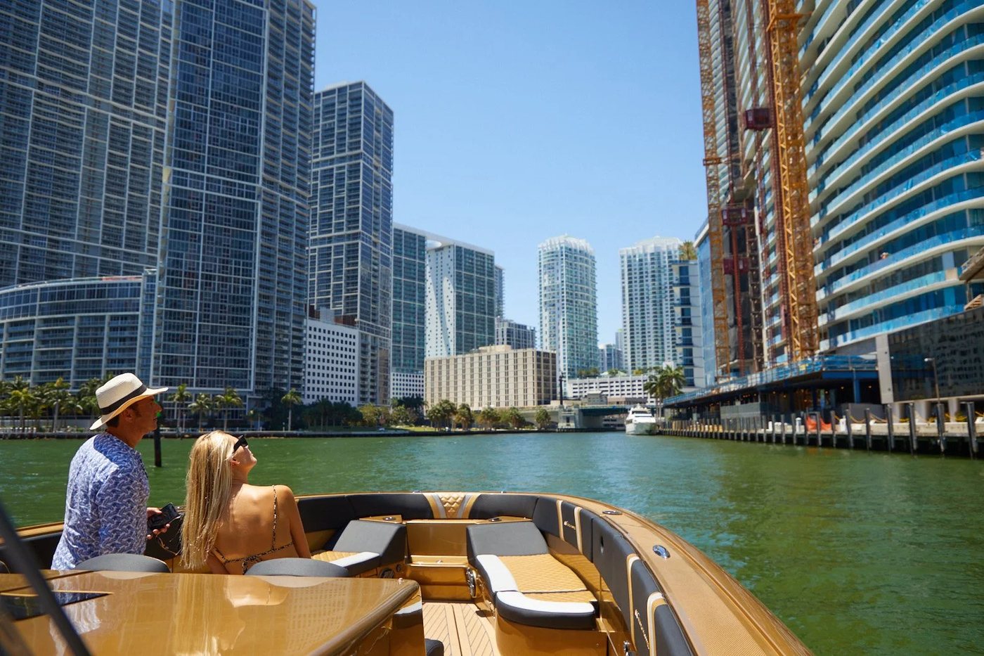 Guests on the bow of a charter boat looking up at the Brickell towers on the Miami River