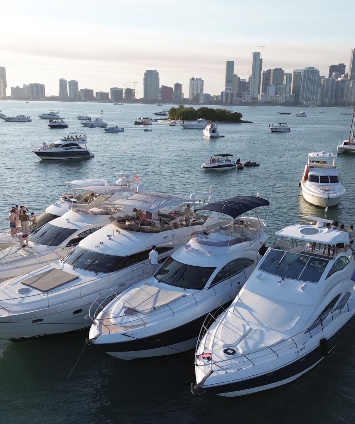 Guests swimming and relaxing beside a multi-yacht raft-up in Miami