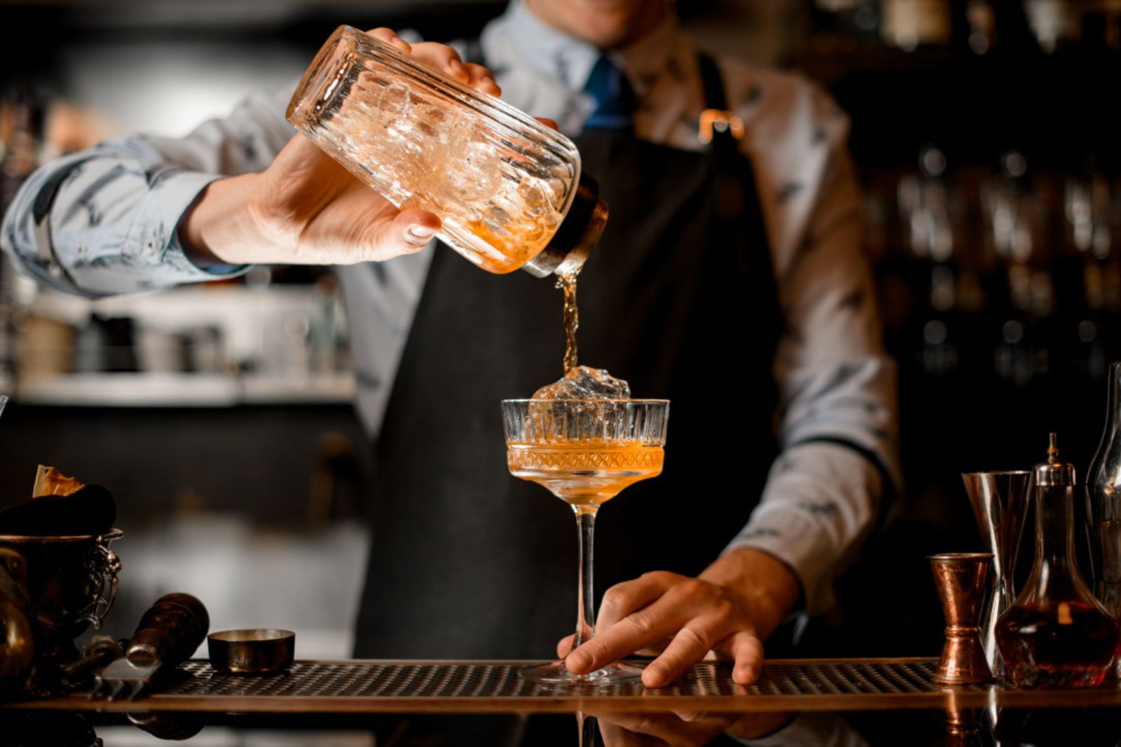 Bartender and Mixologist — craft cocktail being poured