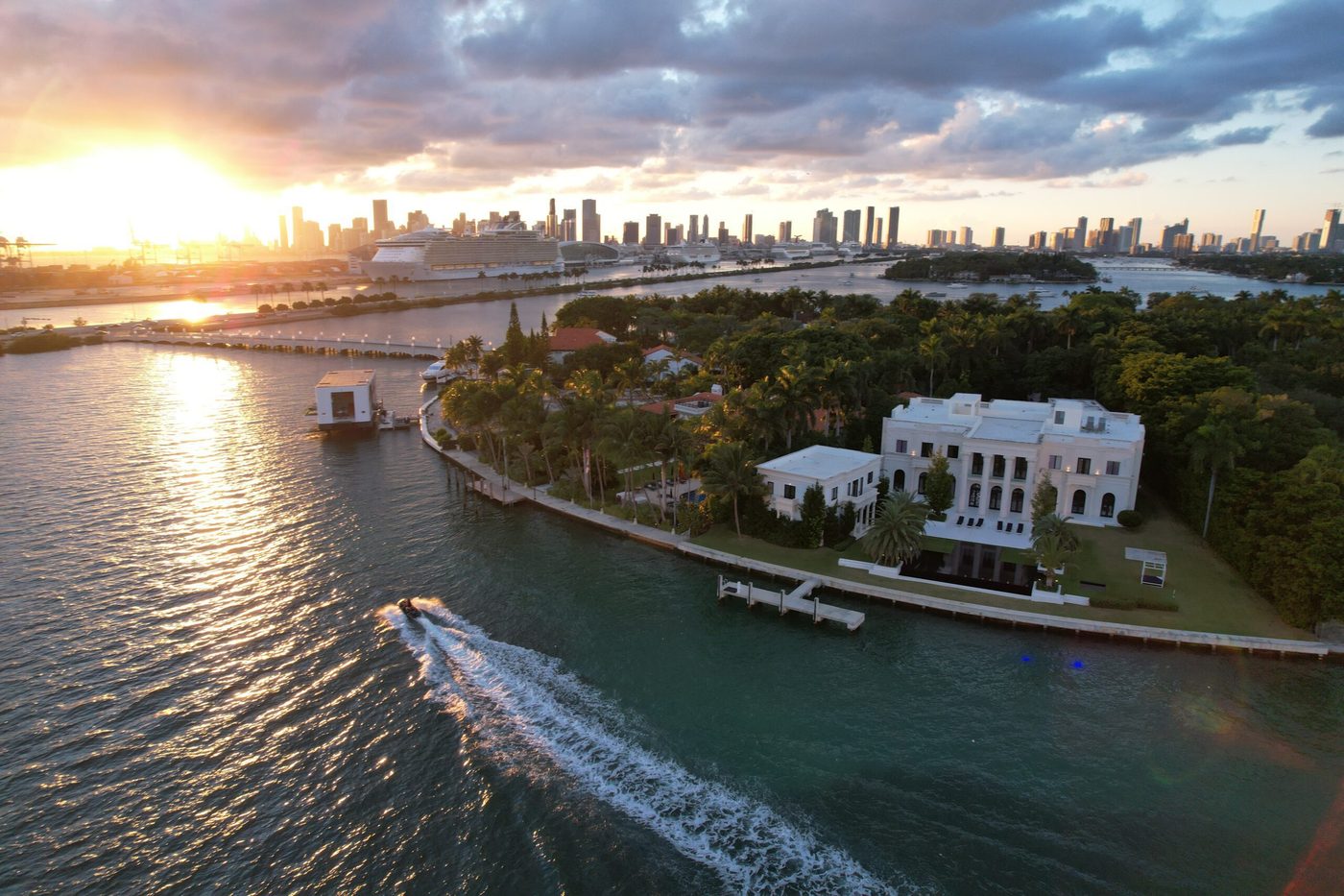 Star Island mansion at sunset with the Miami skyline, seen from a yacht charter